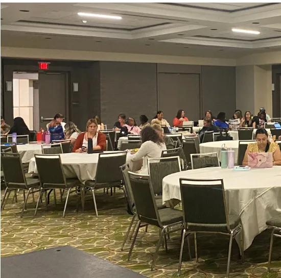 people sitting in a conference room at round tables