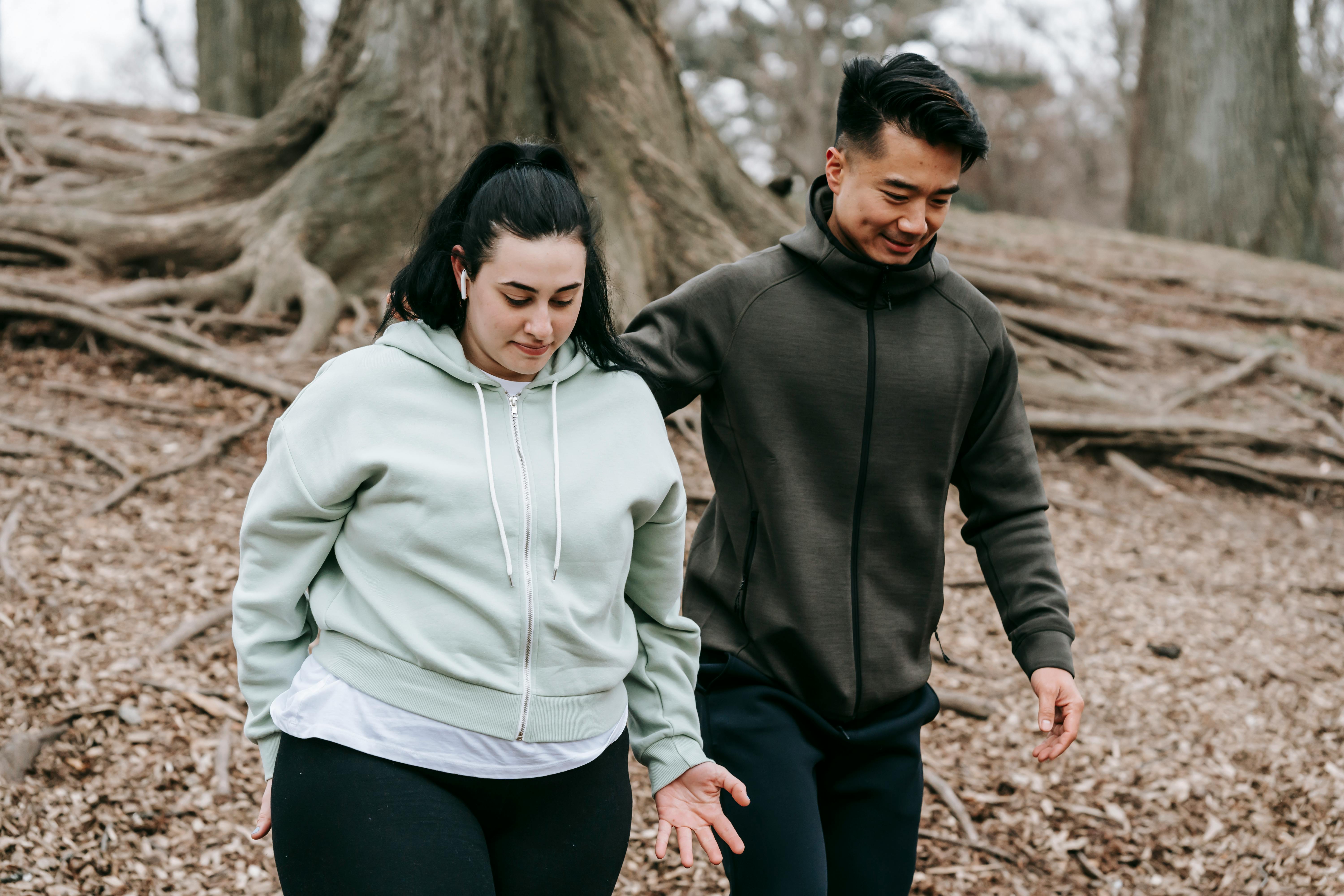 man and woman walking in the woods