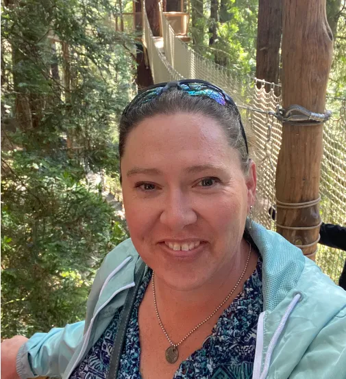 Deidre smiling in the woods