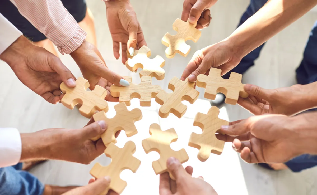 hands holding puzzle pieces together