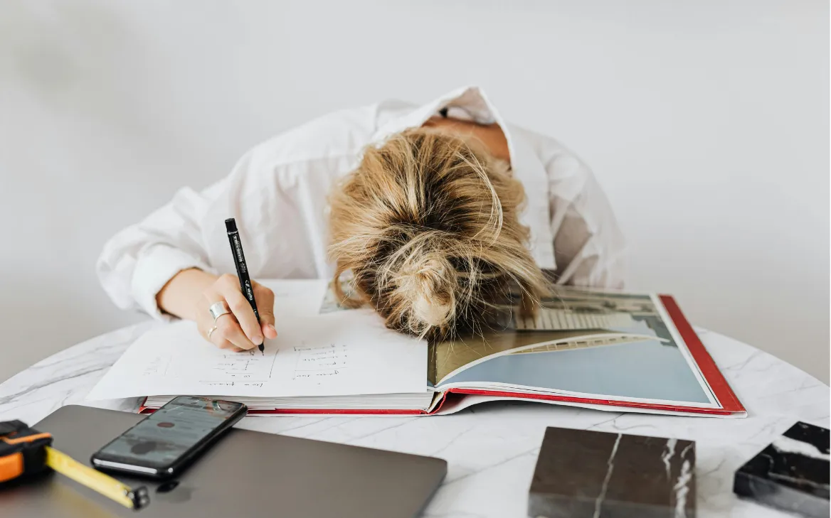 woman with head on notebook