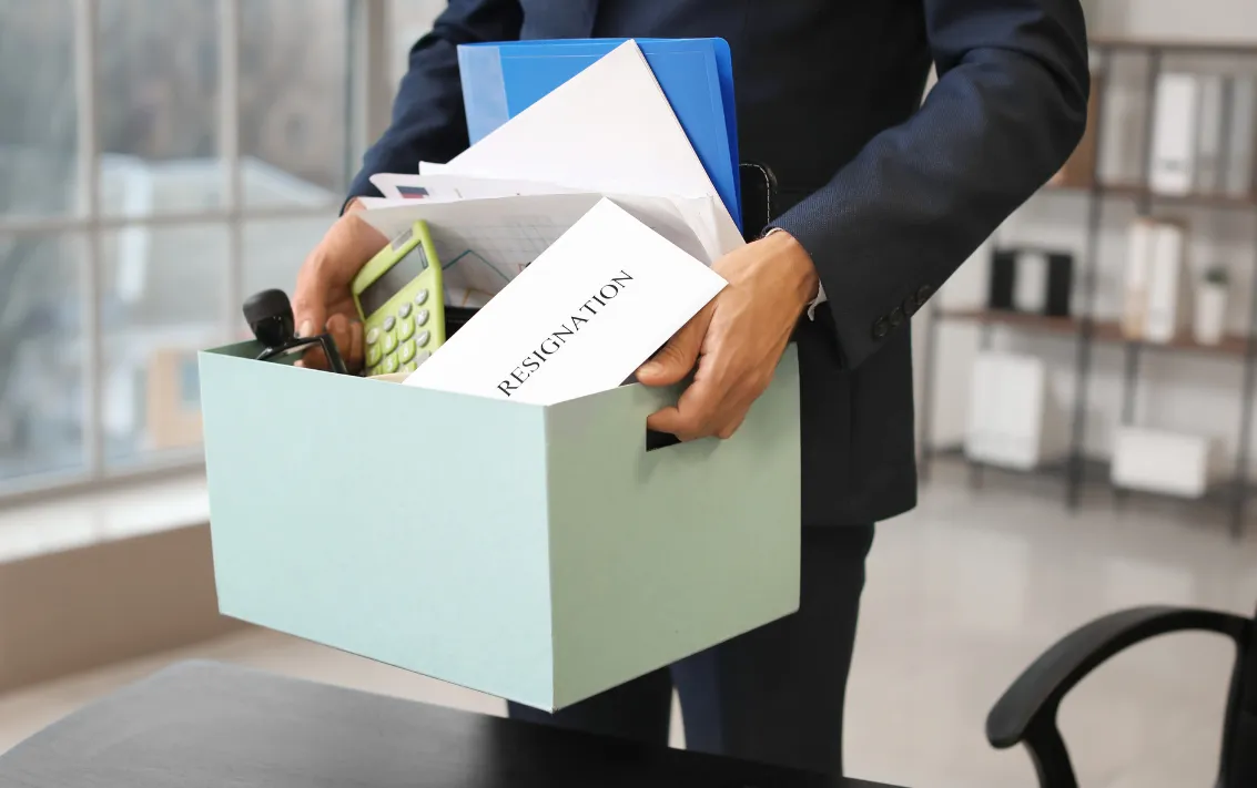employee carrying box of office stuff