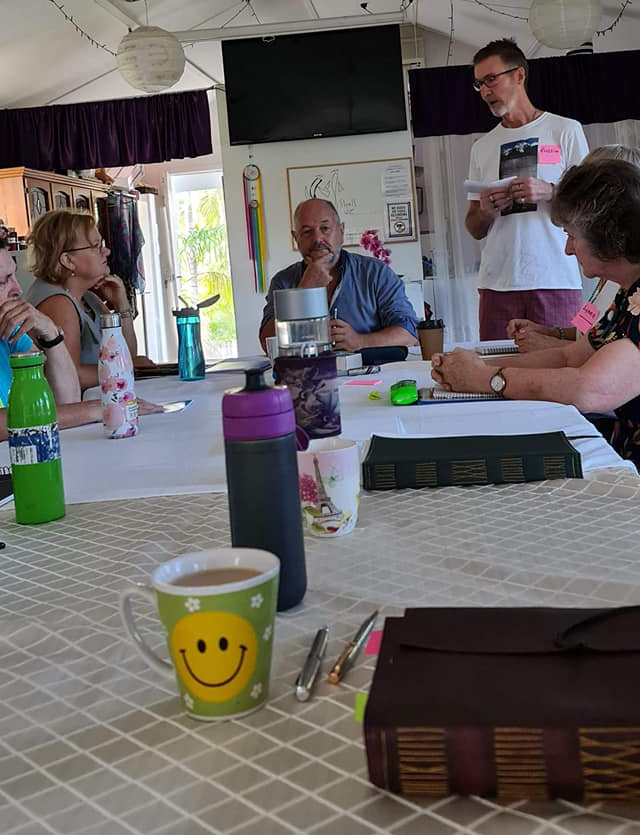 Portrait portfolio image of a quiet studio corner with a lamp, notebooks, and a cup.