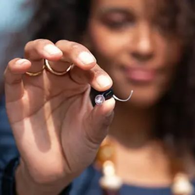 hand holding the oticon zeal hearing aid