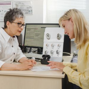 patient and audiologist choosing a hearing aid