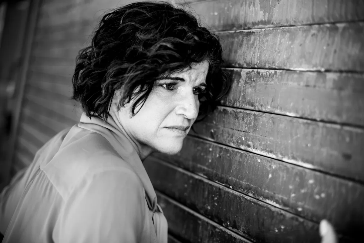 Woman leaning against wall, showing signs of nervous system stress and burnout