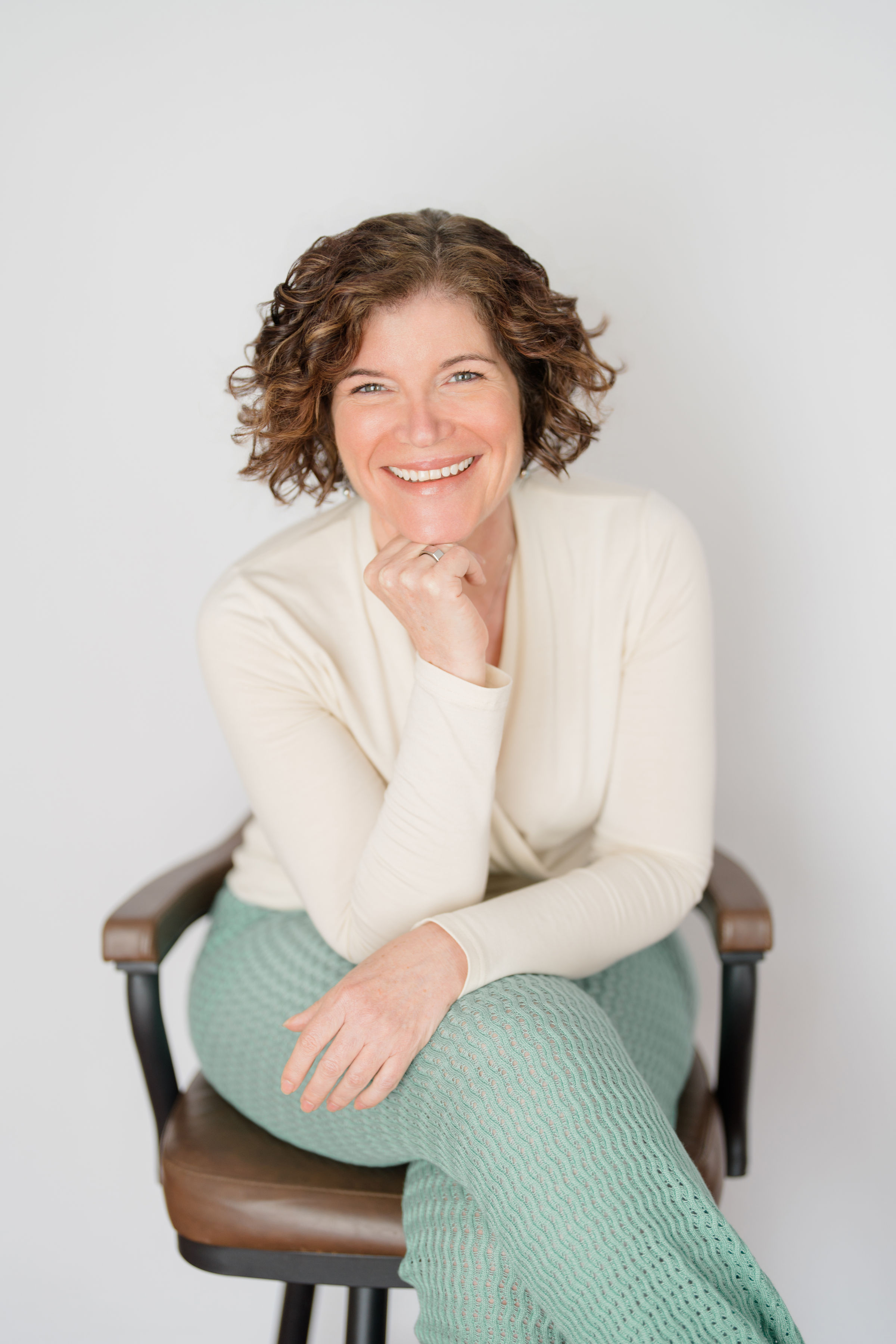Katie Wrigley, nervous system regulation coach, smiling in cream sweate