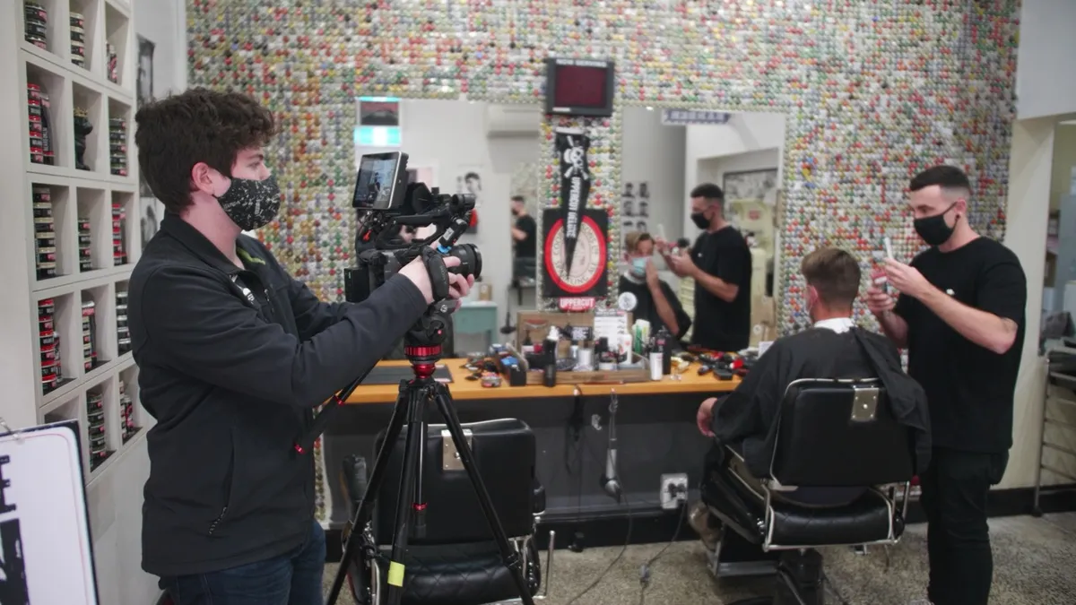 Camera operator filming a salon team during a workplace tour