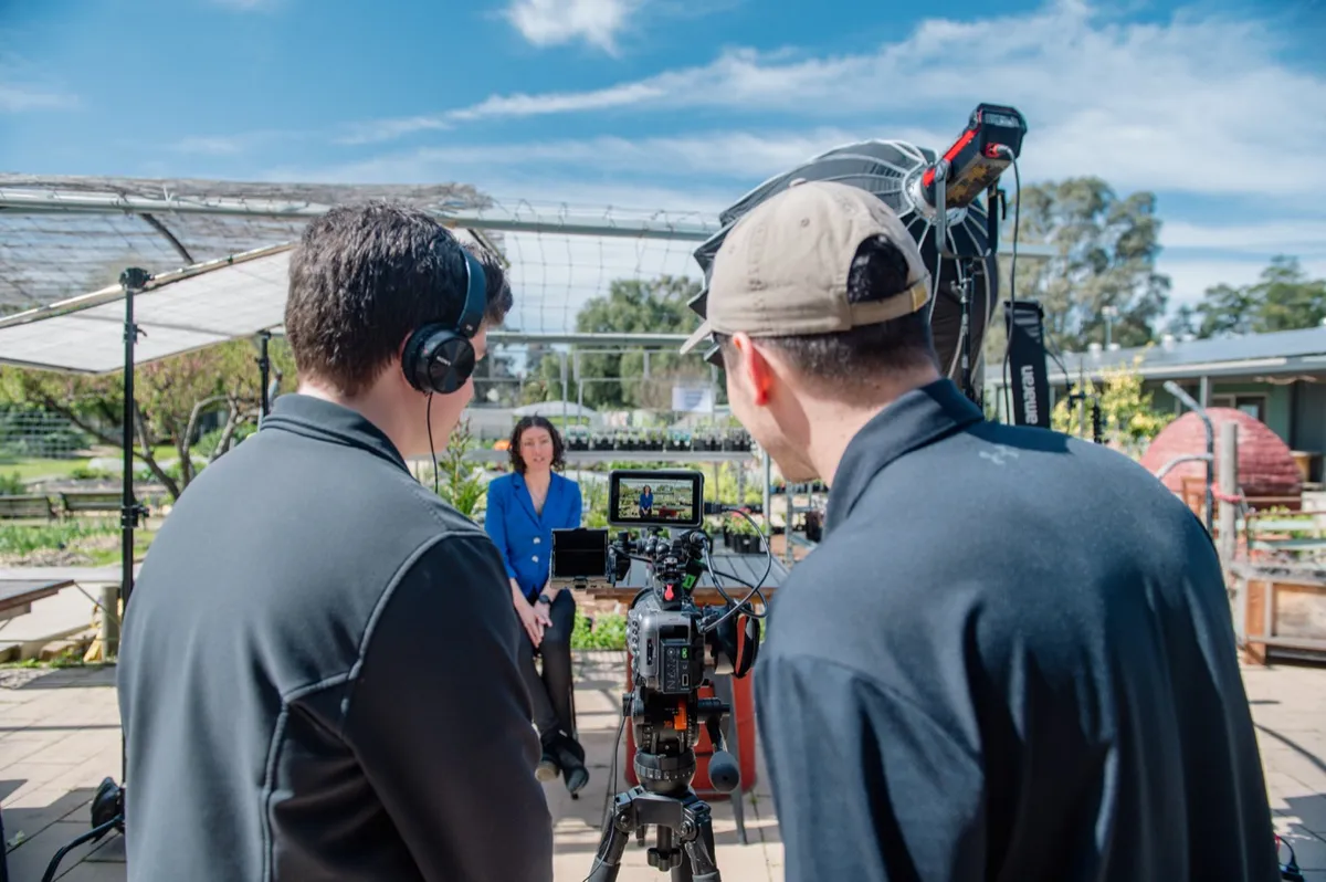 Two crew members checking the interview camera at the plant nursery