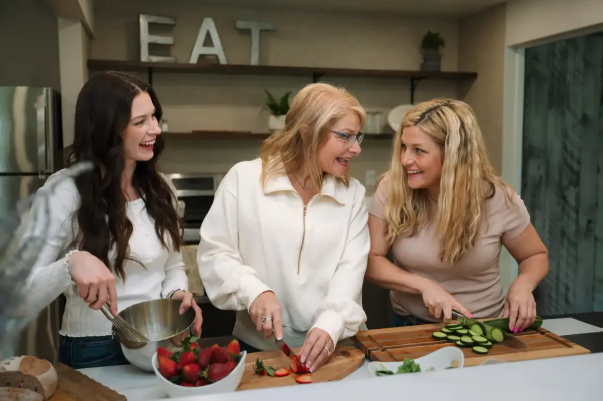 Three Fast to Faith women laughing together in a kitchen