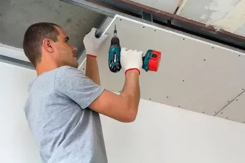 Worker installing new drywall ceiling during mold repair – Huntsville Mold Removal Pros.