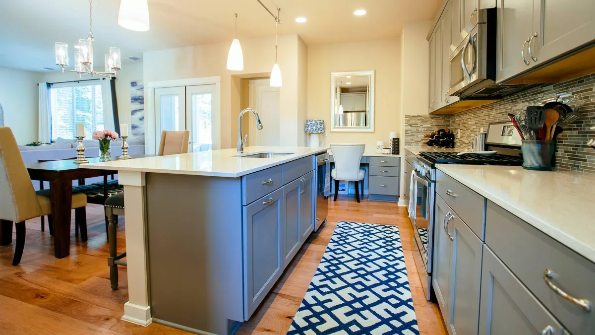 a kitchen with a white countertop and a blue and white rug