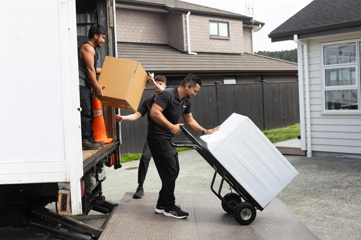 Couple packing moving boxes in a living room, preparing for a stress-free move with Pro Moving Services.