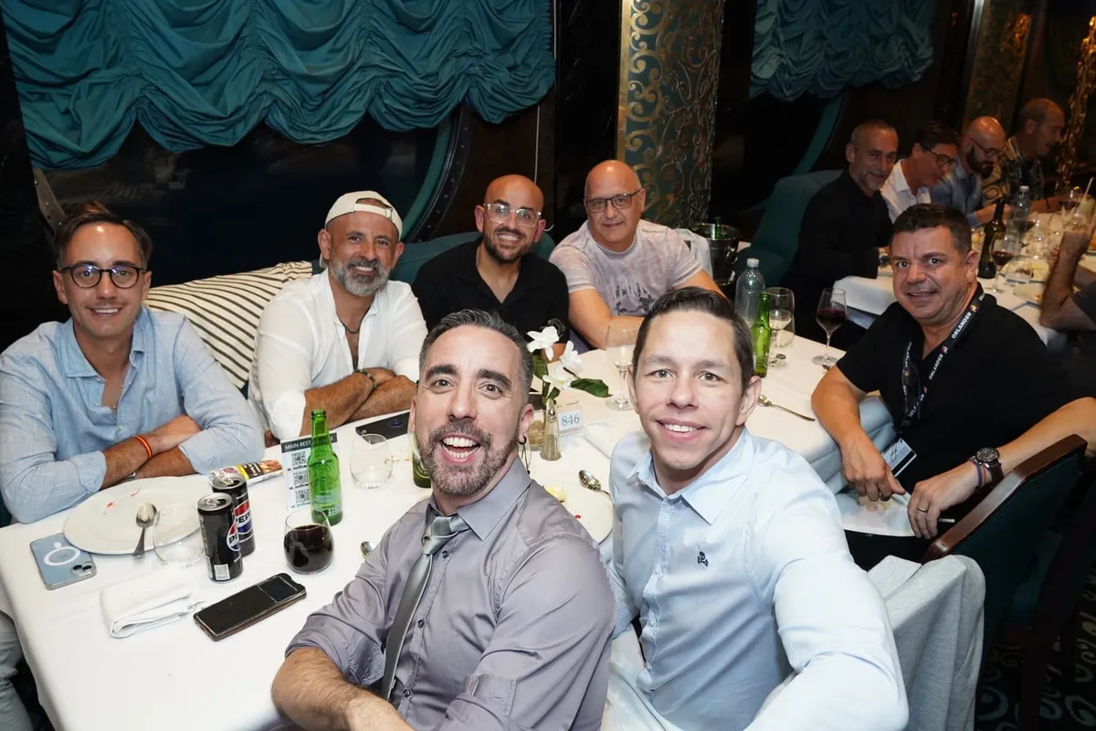 Grupo de hombres sonriendo juntos en una cena, un plan para conocer gente sin depender de las apps