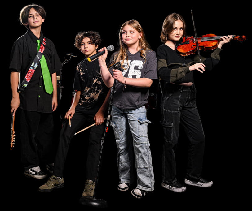 Group of young musicians playing guitar, drums, vocals, and violin during a Rockstars of Tomorrow band performance program.