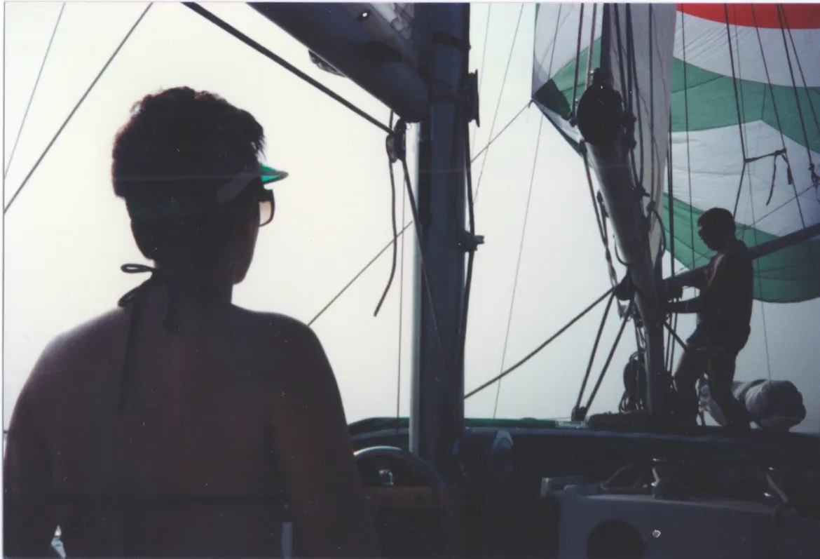 Dr. Arden steering Shamrock with crew raising the spinnaker sail in deep fog.