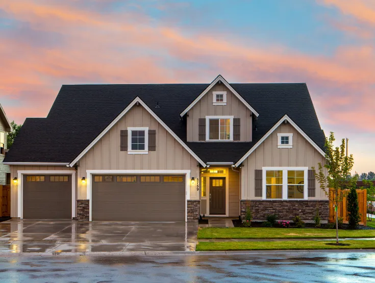 Custom built residential home with attached garage stone accents and landscaped yard constructed by experienced home builders in North Carolina