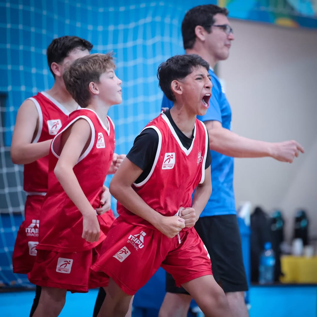 Basketball players reaching for ball near hoop