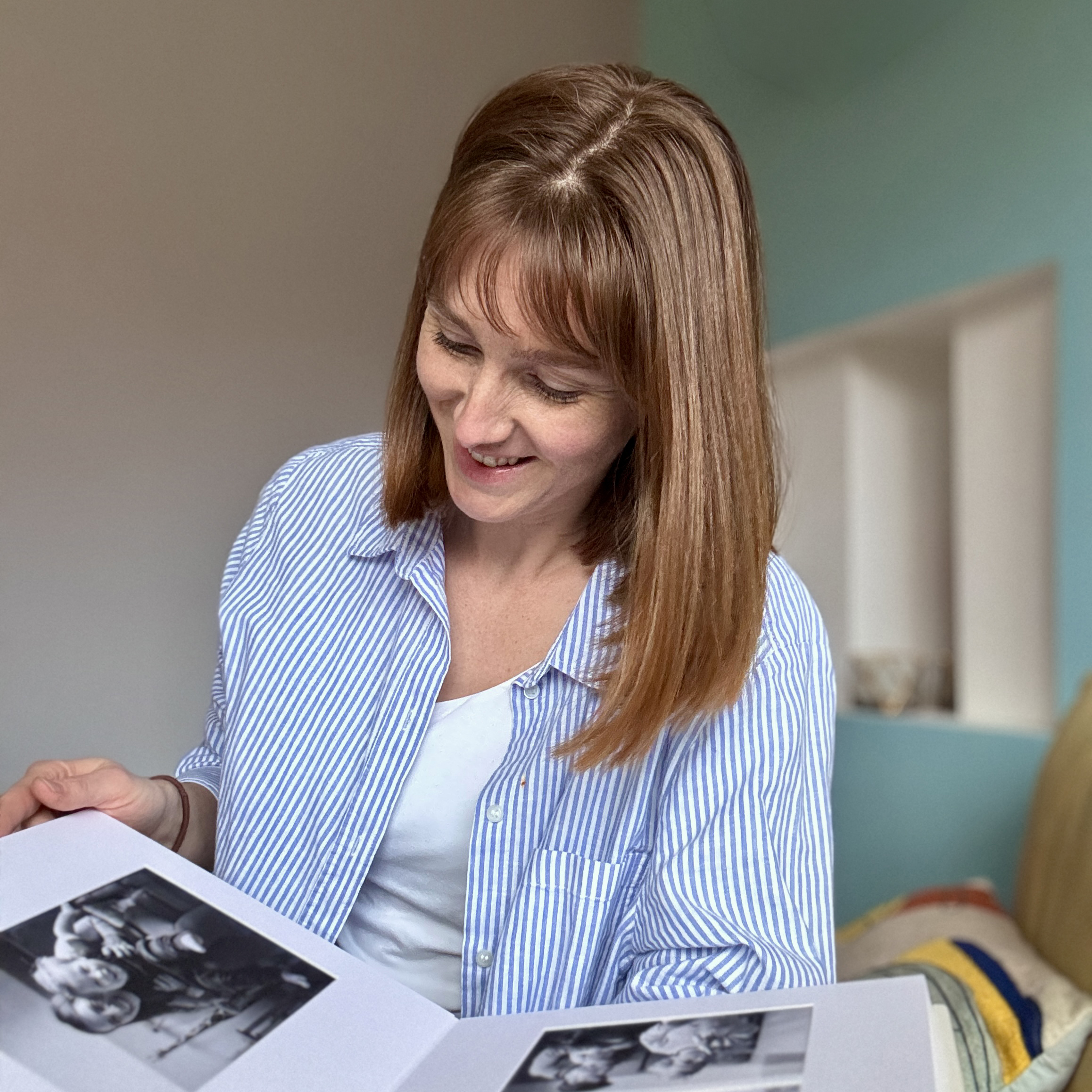 Family photographer looks at heirloom album created from one of her family portrait sessions
