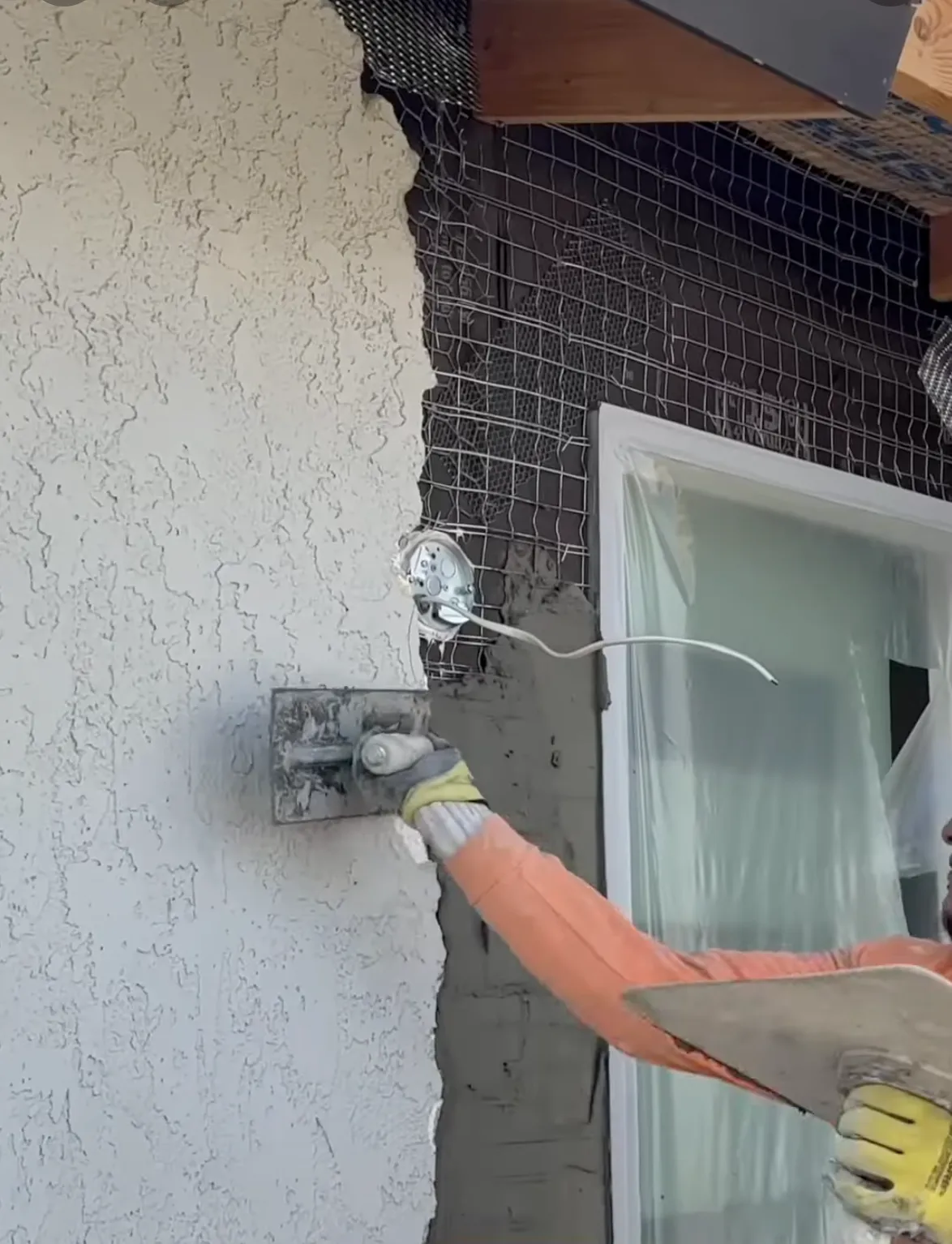 man applying new stucco to wall