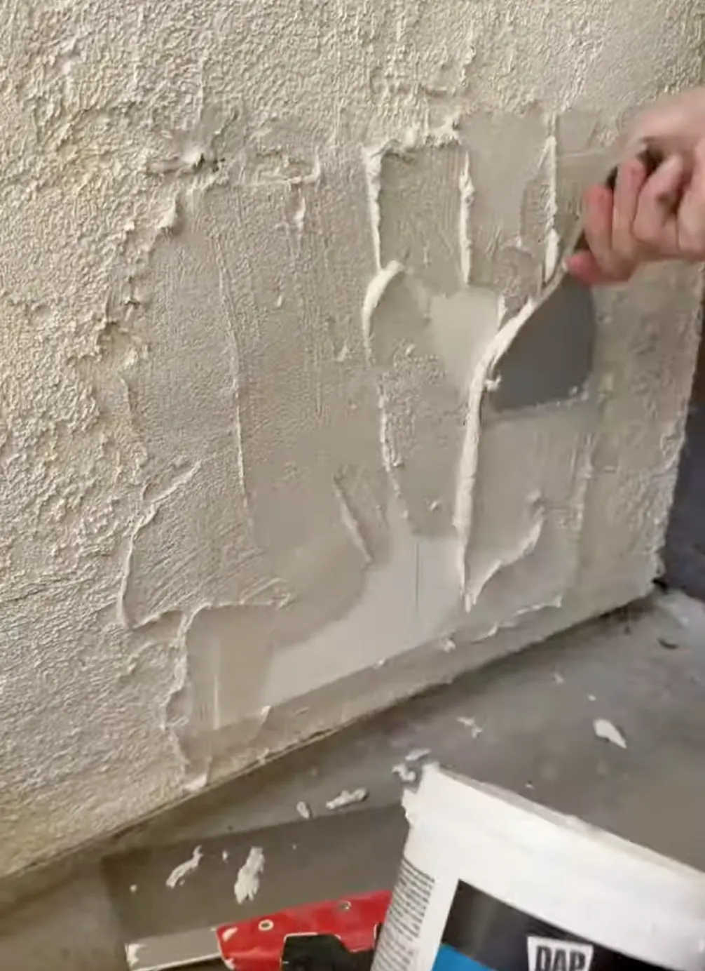 man applying new stucco to a wall