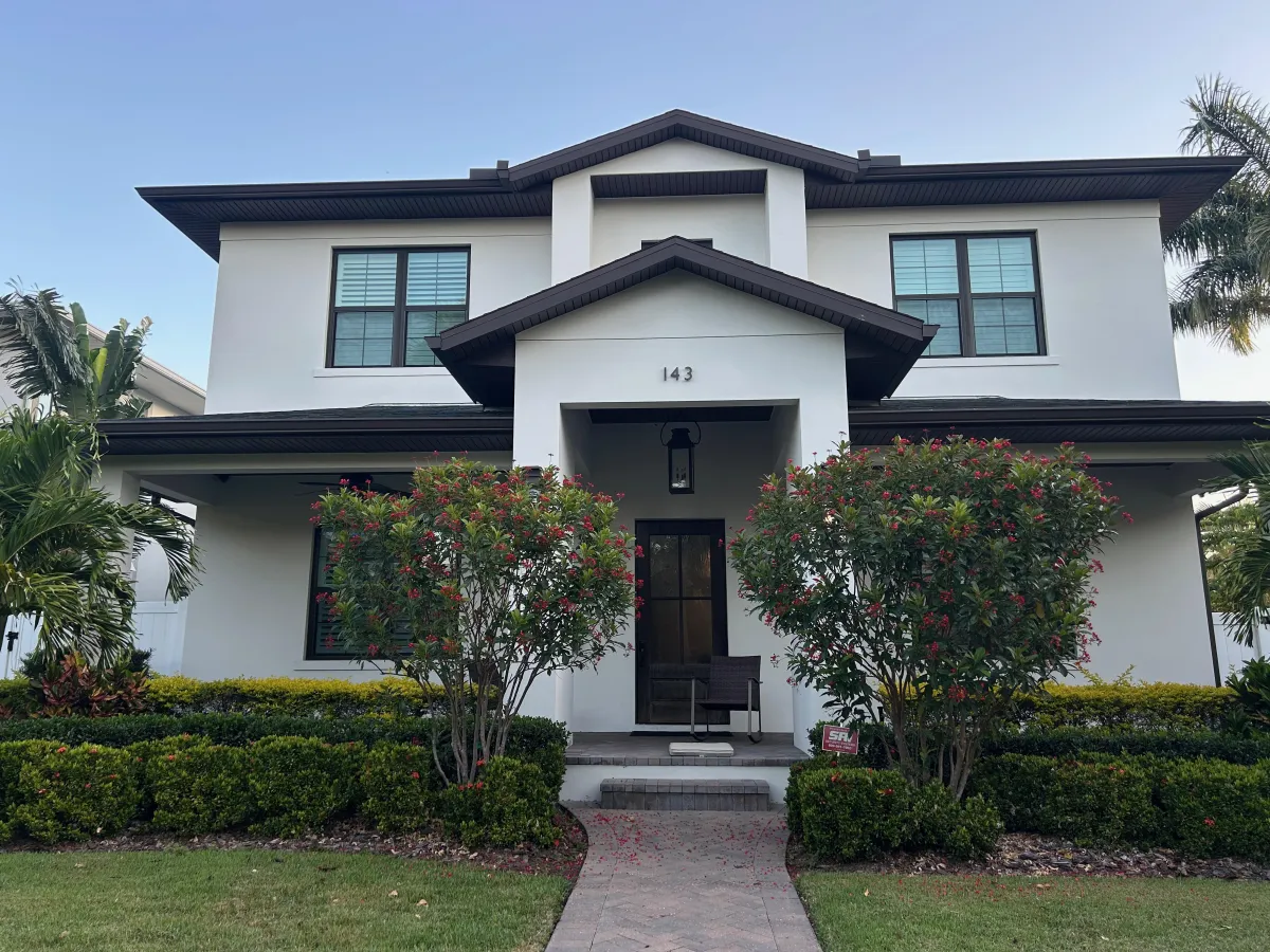 Smooth white stucco on house with two trees in front