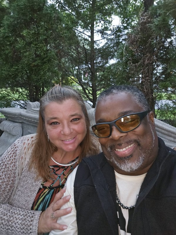 White woman and Black man smiling together in a bright setting