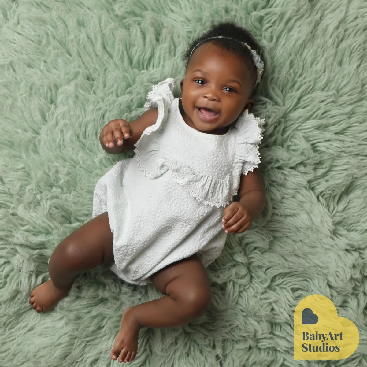 Baby smiling while laying on a blanket - Professional baby photos taken by baby art Manchester