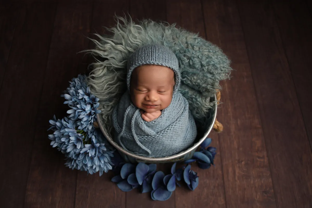 Baby in a blue bundle and basket, taken by photographer in Edinburgh