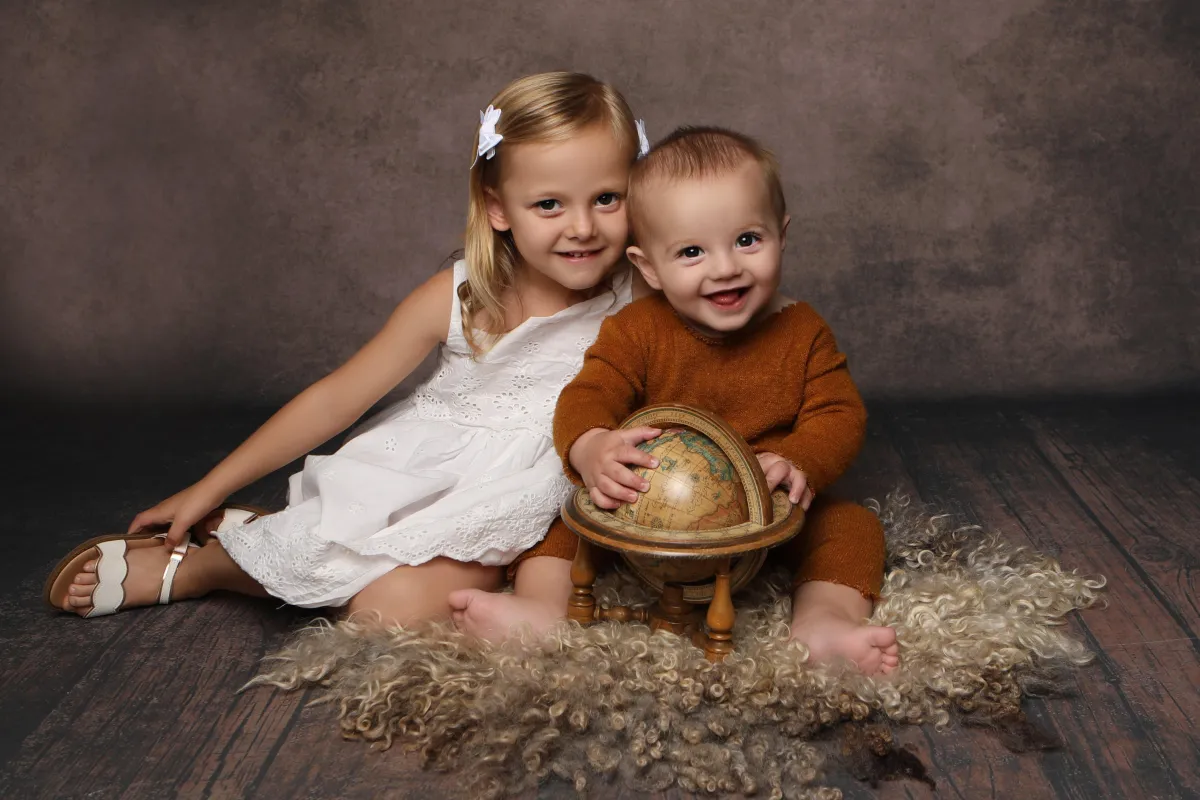 Young siblings sitting together - Professional baby photos taken by baby art Manchester