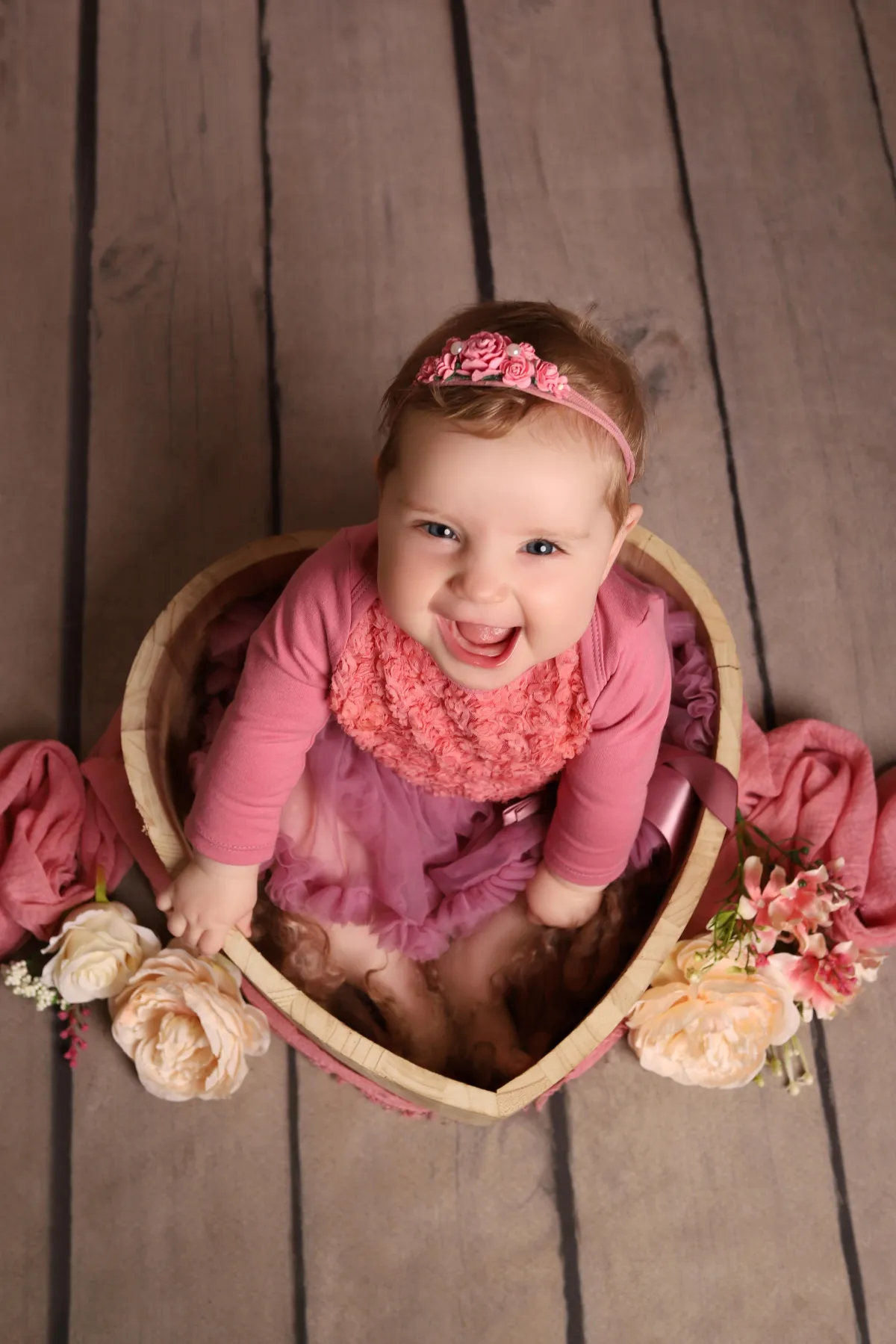 Photo of baby sat in wooden love heart, taken by professional photographers in Kent