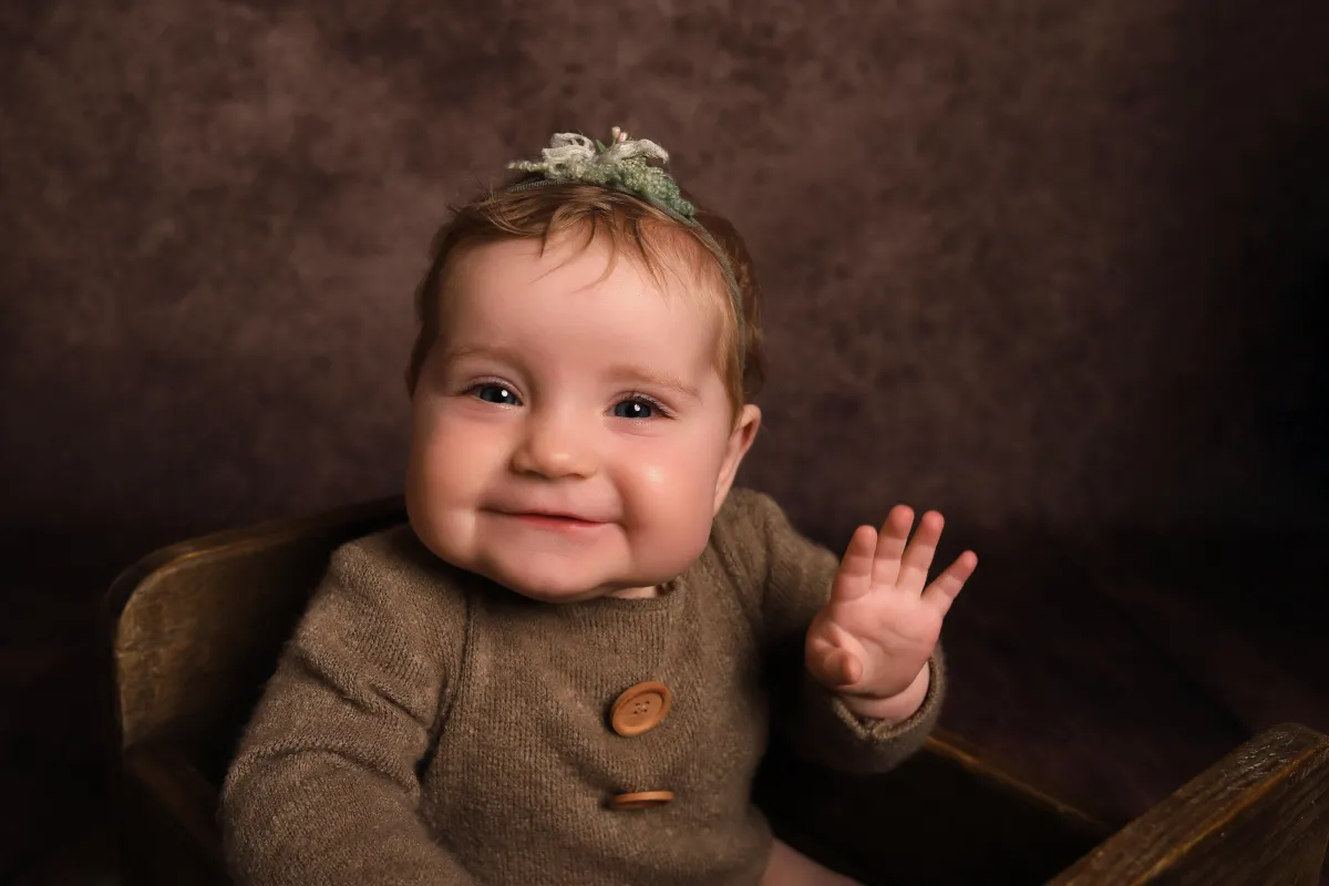 Photo of baby waving at camera, taken by professional photographers in Kent