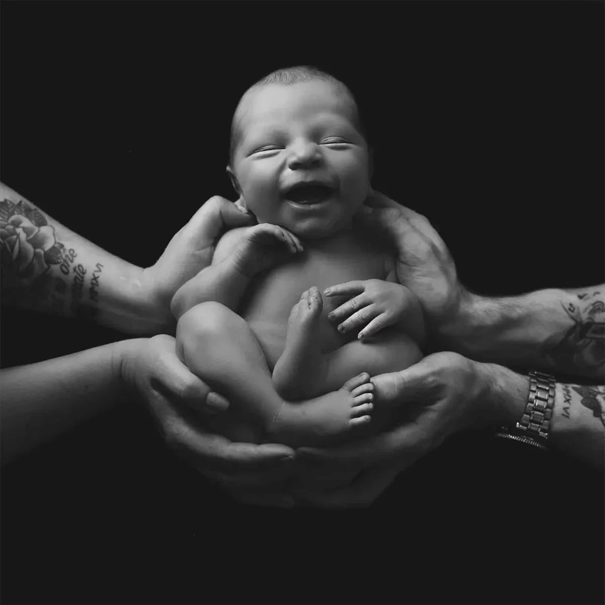 Black and White photo of baby being held by its parents for Baby Art Studios Gallery