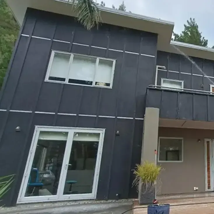 Window cleaning service on modern home exterior by Tiki Blasting in Gisborne