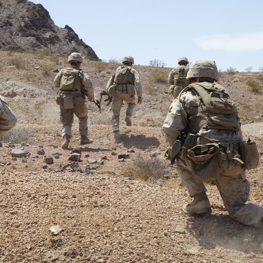 a group of soldiers moving forward and climbing a mountain