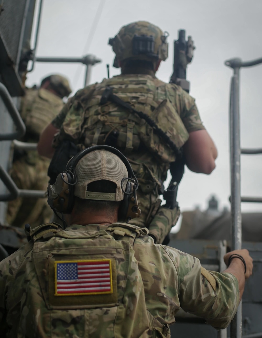 soldiers in gear climbing up a straircase