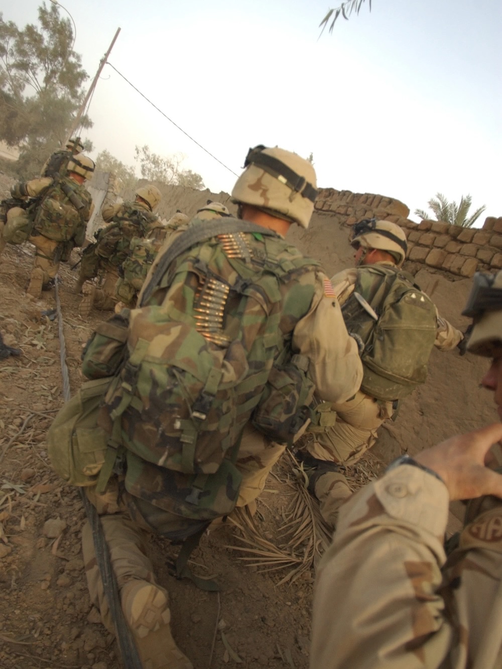 soldiers moving through the street during the day with gear