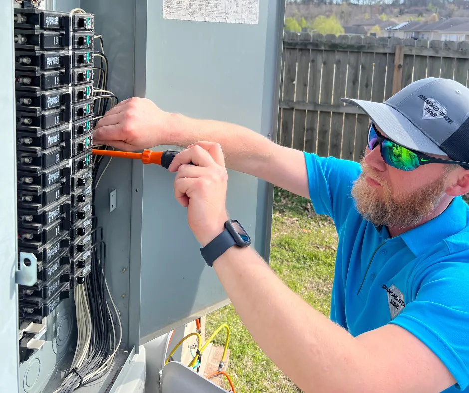 Electrical technician working on wiring in a residential panel