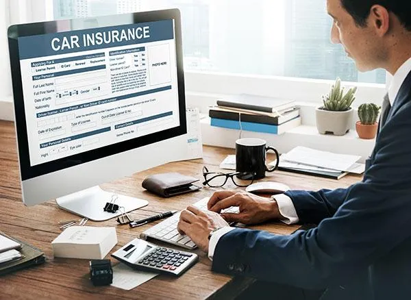 Man filling out an auto insurance application on computer