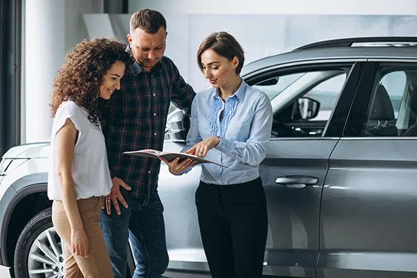 Salesperson presenting information about a vehicle to buyers