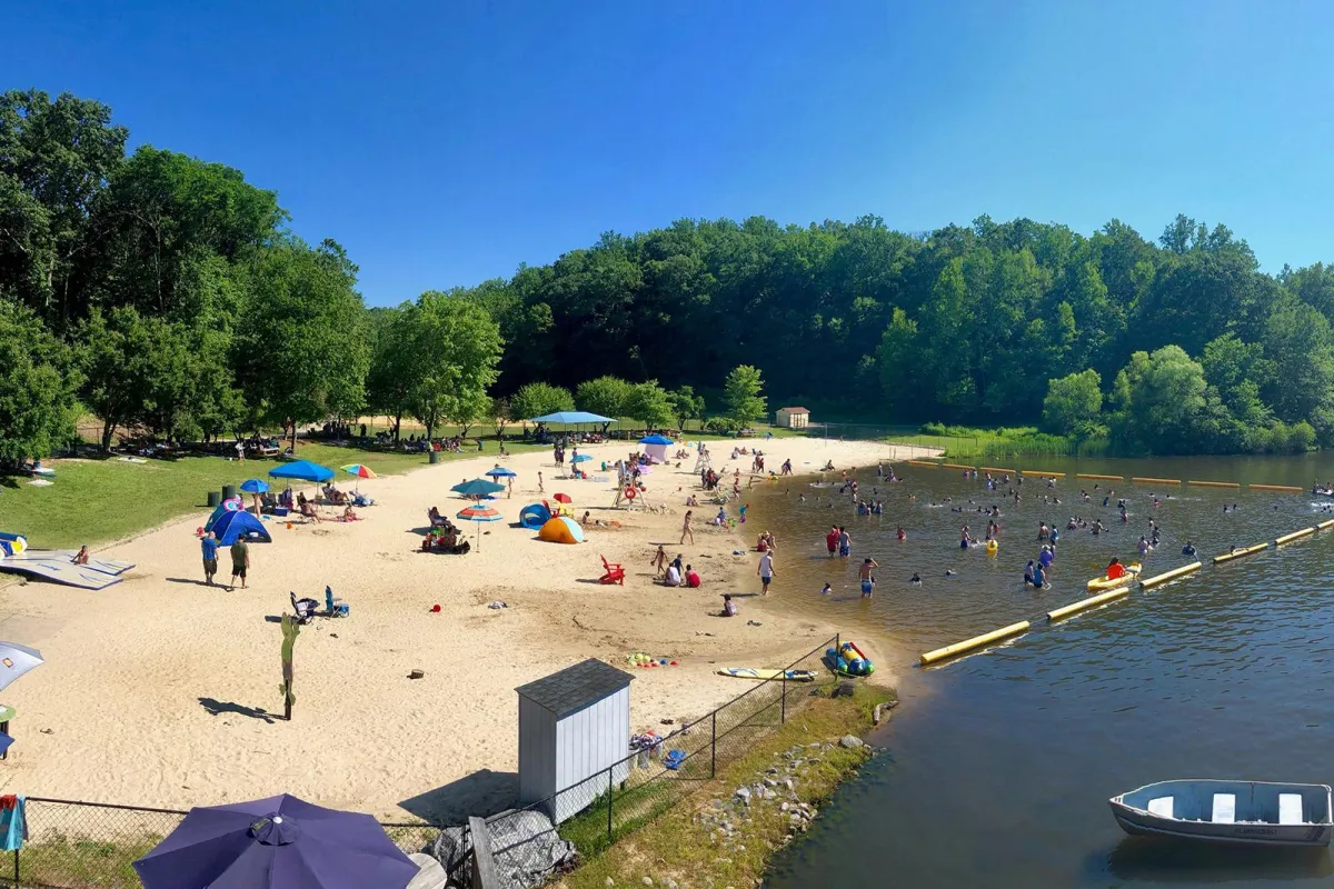 Sunny lakeside park in Morris County NJ with people enjoying picnics, concerts, and summer activities.