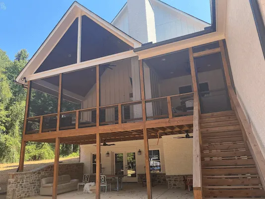 Technician closing a newly installed screen beside a bright window