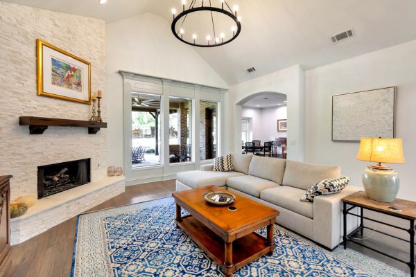 Professional plumber kneeling under a kitchen sink, using tools with confidence. The background shows a tidy, modern kitchen with subtle holiday touches. 3:2 aspect ratio.