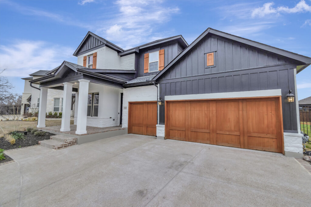 Professional plumber kneeling under a kitchen sink, using tools with confidence. The background shows a tidy, modern kitchen with subtle holiday touches. 3:2 aspect ratio.
