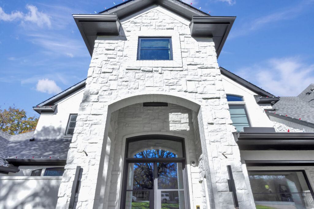 Close-up of a dripping kitchen faucet with a worried homeowner in the background, holiday decorations visible. The image highlights the urgency of plumbing issues during festive times. 3:2 aspect ratio.