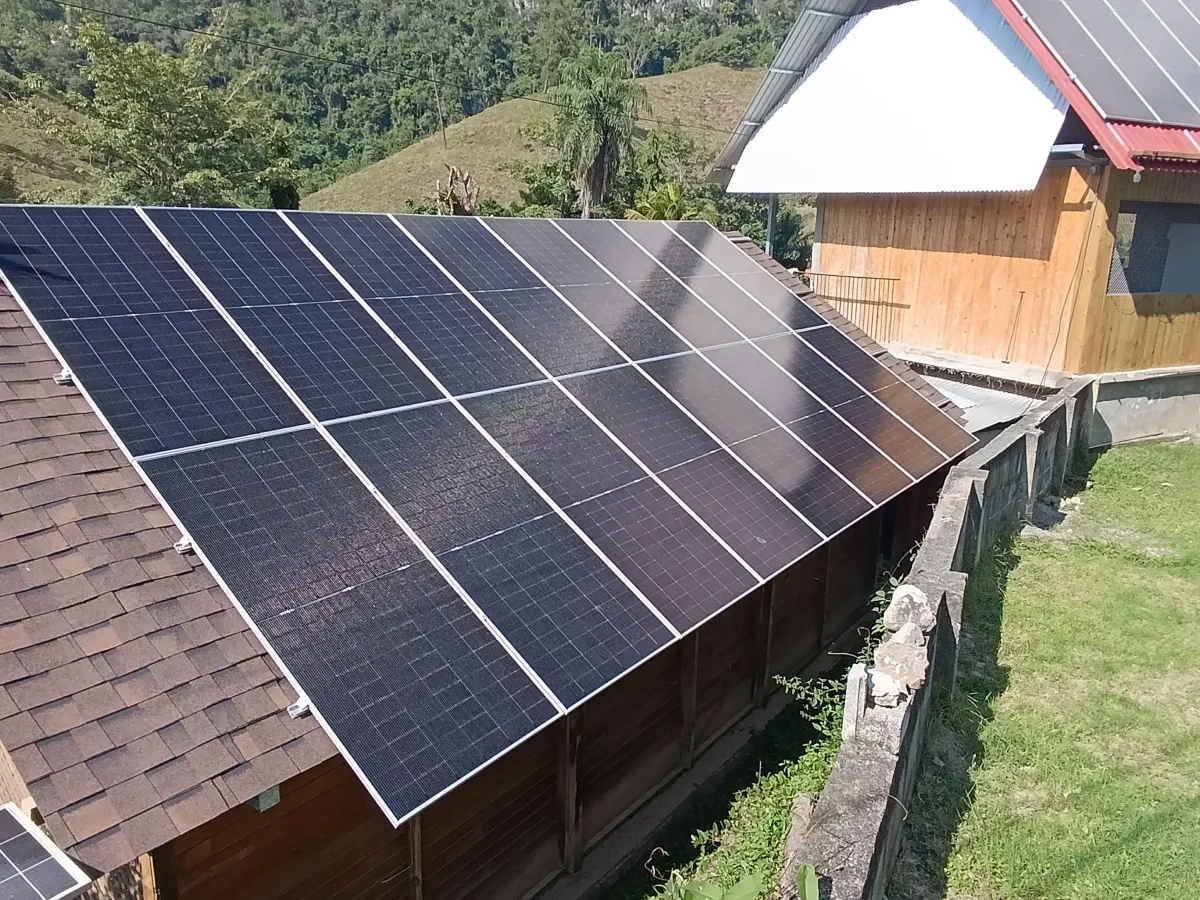 Paneles solares en techo de casa familiar en Resistencia, Chaco, día soleado, niños jugando en el jardín
