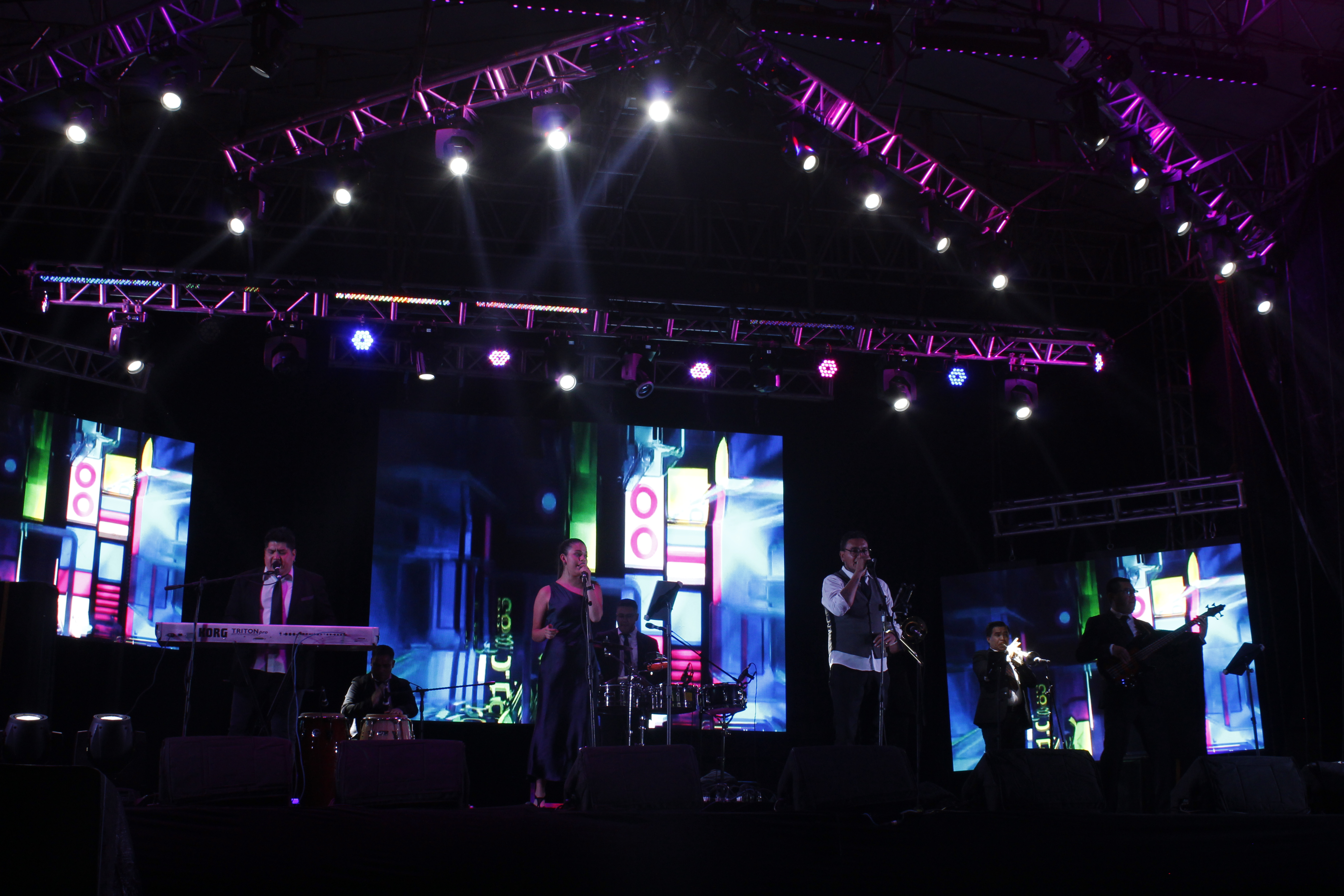 Event coordinator adjusting stage lighting with small business team enjoying a transformed modern conference room.