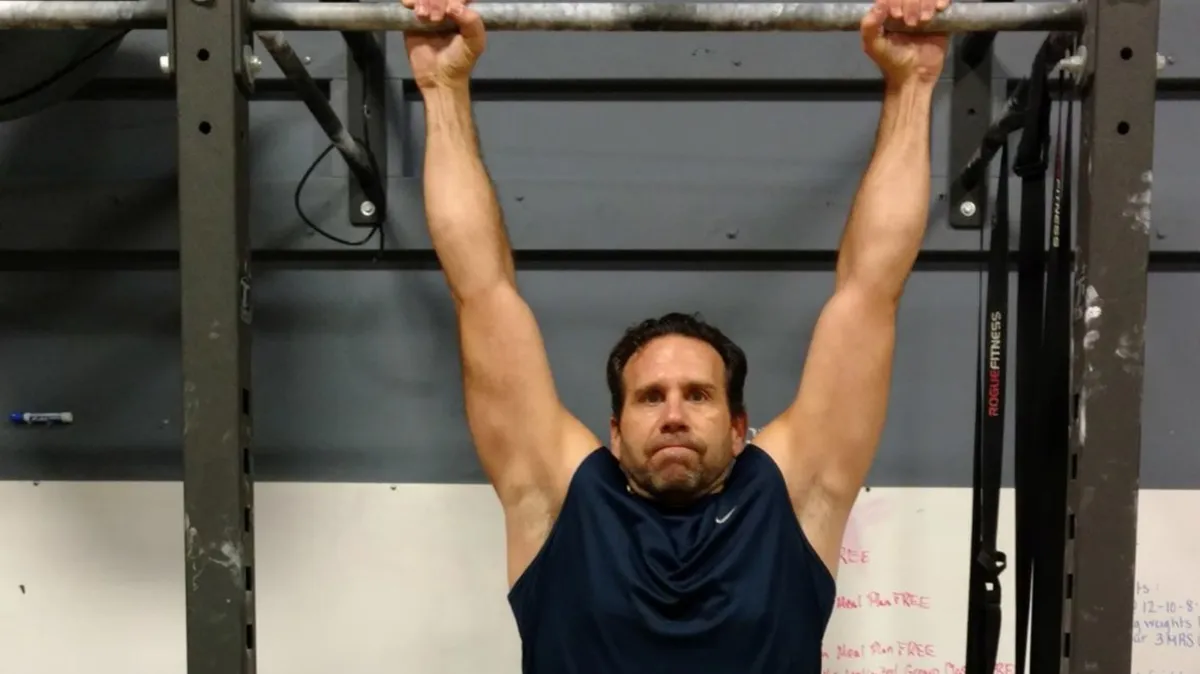 Man hanging from a pull up bar at 4Balance Fitness