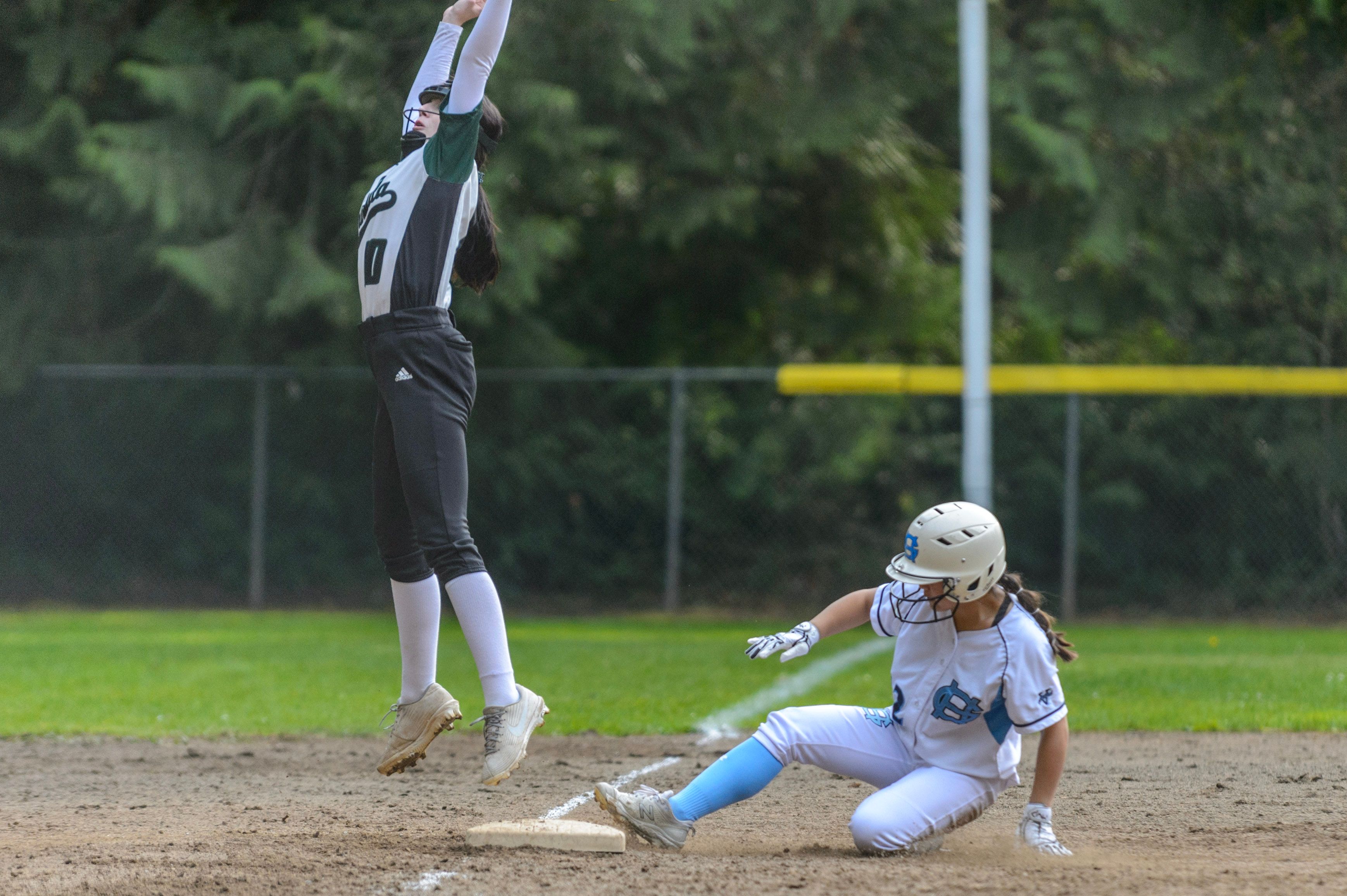 Softball player fielding a throw as a runner slides into base — 4Balance Forge online softball training