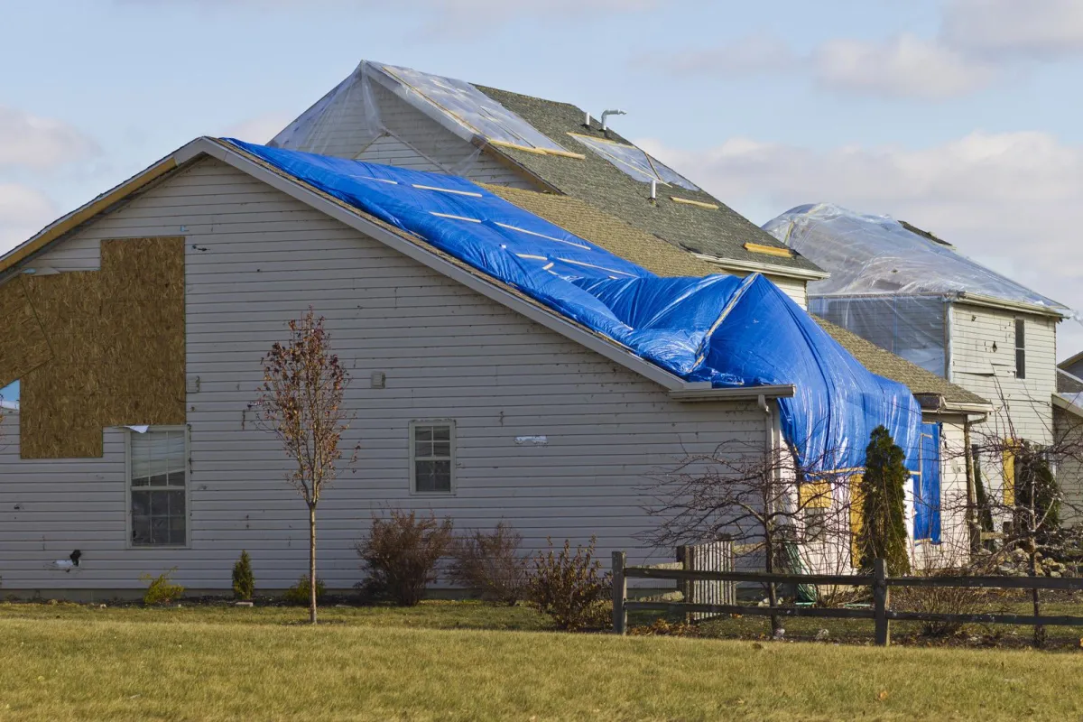 House boarded up and tarped after a heavy storm, demonstrating the impact of severe weather and the importance of emergency restoration services from VHrestoration.